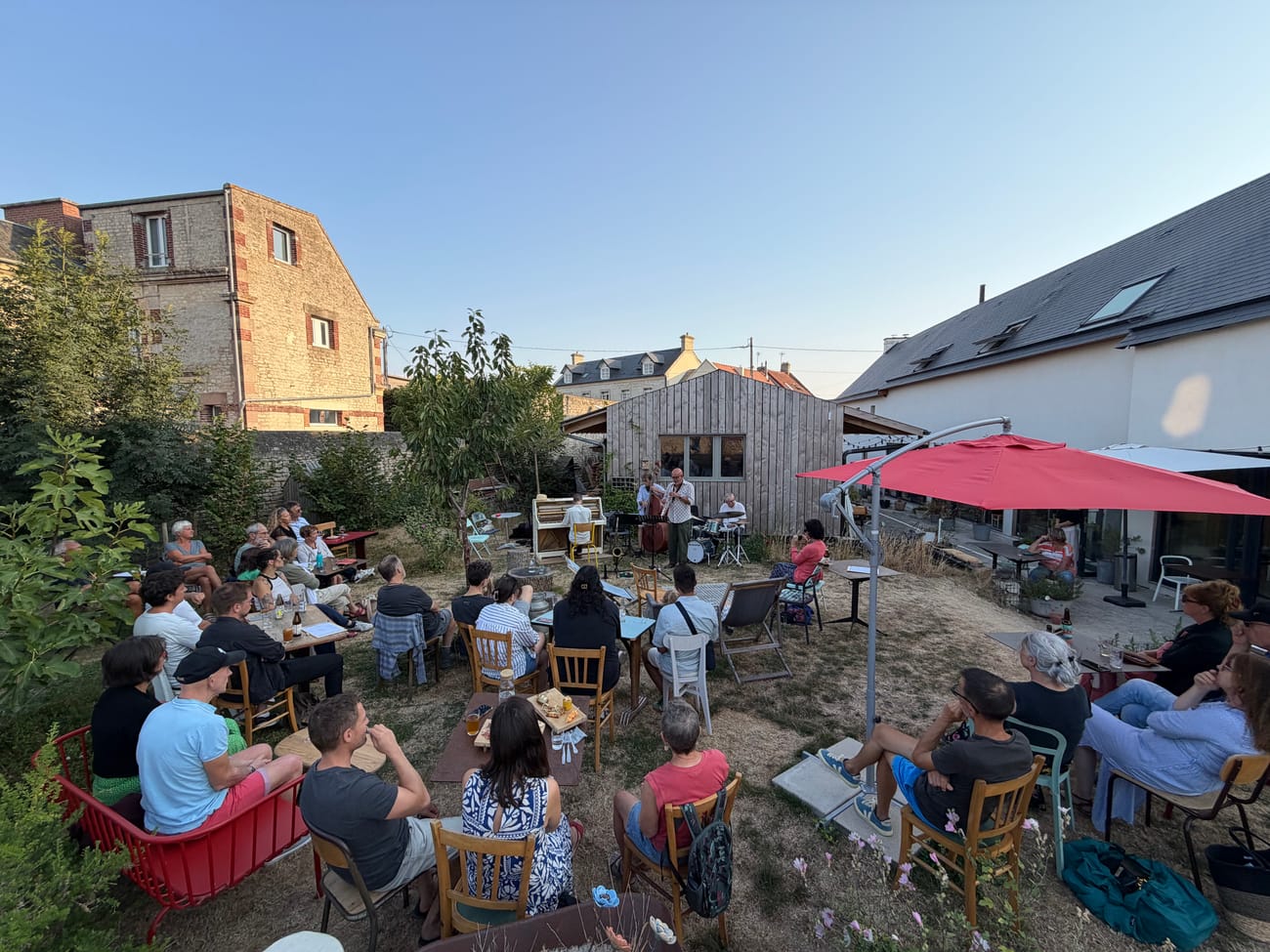 Soirée dans le jardin des Briques, guirlandes et parasol rouge