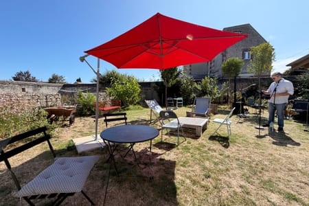 Le jardin prêt pour une soirée, parasol rouge et micro